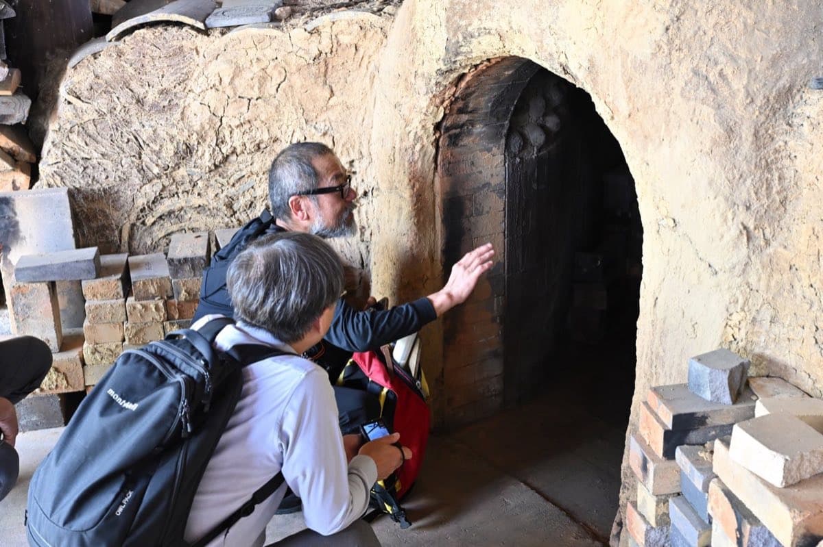 Experts touring the interior of a traditional tile kiln